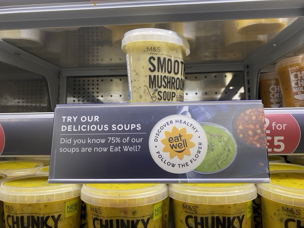 Schapkaart in supermarkt waarop staat dat 75% van de soepen bij M&S gezond zijn.